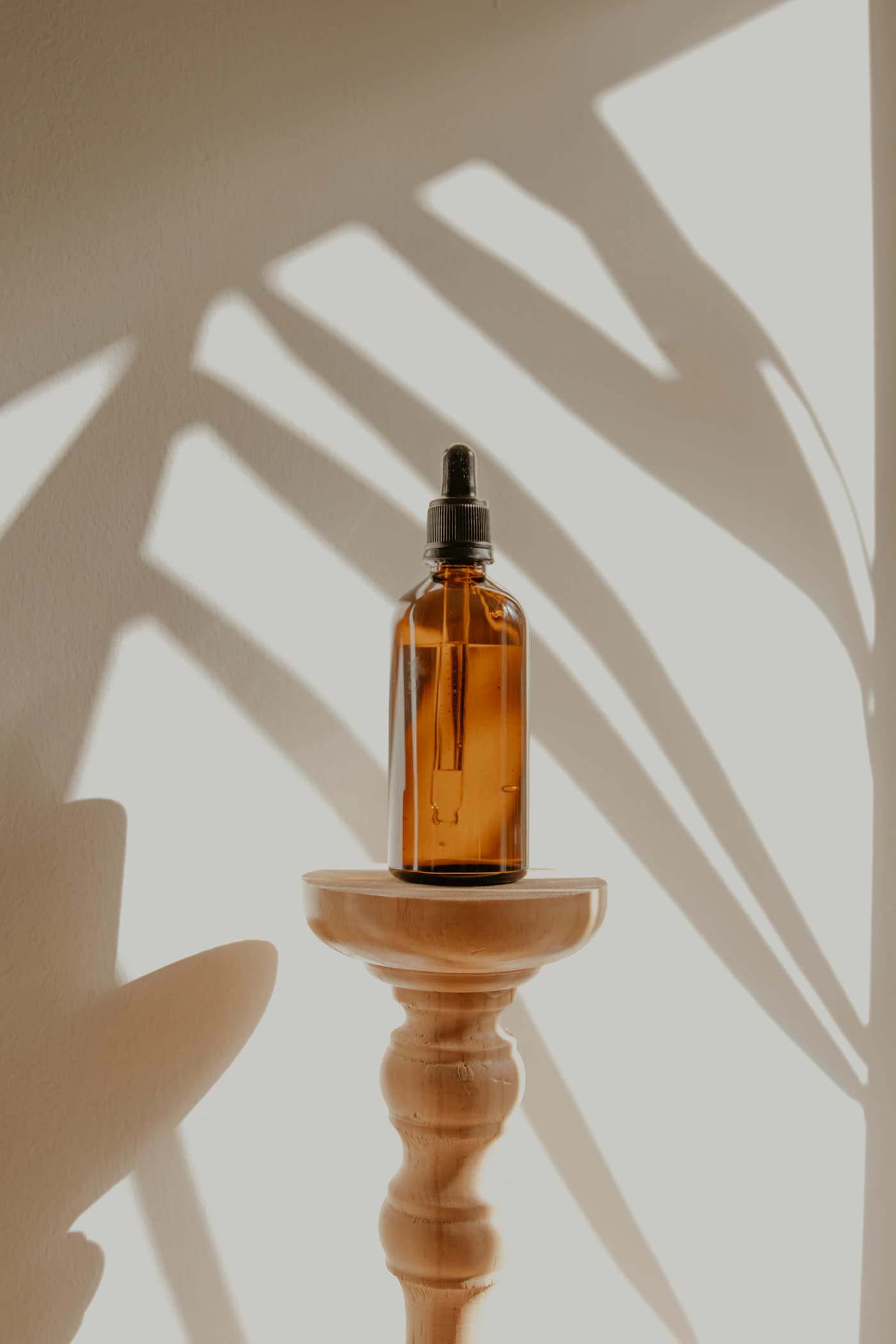 Before: illustrative stock photograph of an amber bottle on a wooden stand